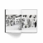 Livre du street artist Yann l'outsider ouvert sur une grande illustration de photos de graffiti dans une galerie avec Yann devant