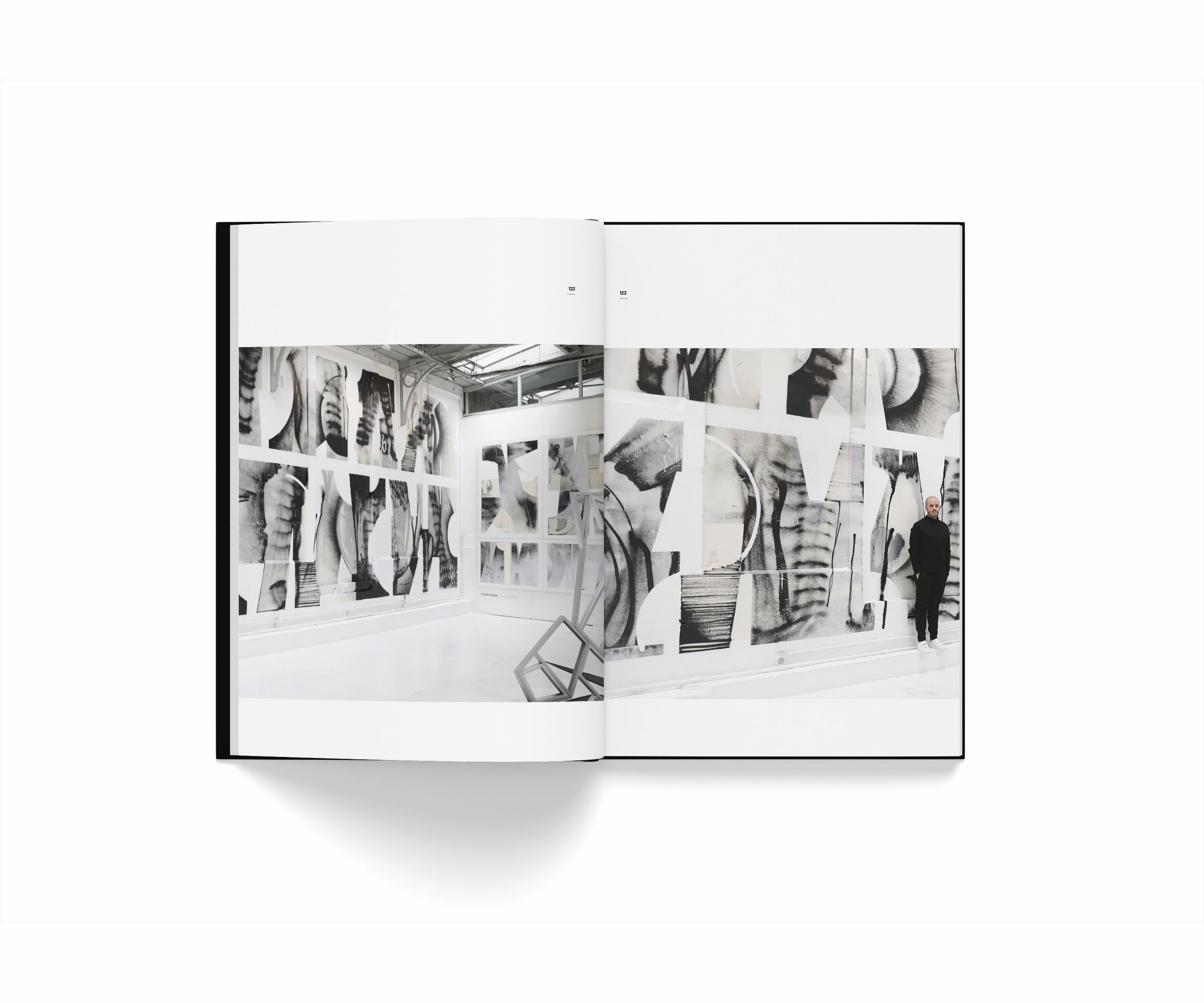 Livre du street artist Yann l'outsider ouvert sur une grande illustration de photos de graffiti dans une galerie avec Yann devant